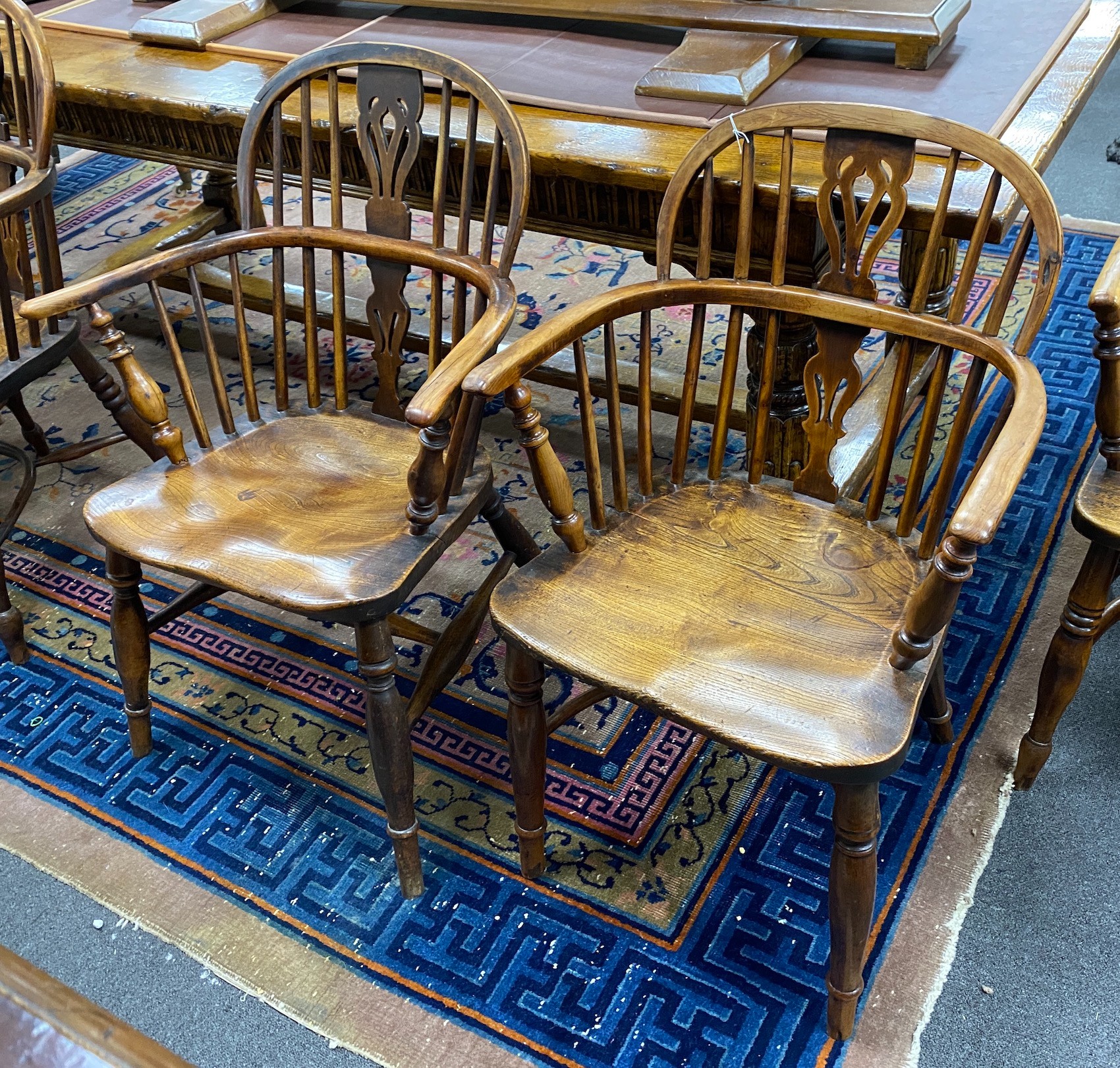 A near pair of mid 19th century yew and elm Windsor elbow chairs, with crinoline and H stretcher, larger width 64cm, depth 48cm, height 87cm